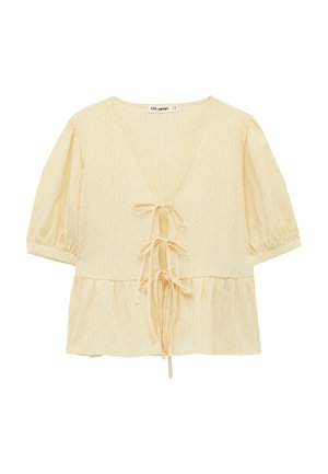 Lichtgele blouse met korte mouwen, subtiele verticale strepen, diepe V-hals, drie strikjes aan de voorkant en een geplooide taille met peplumdetail.