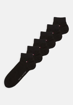 Black ankle socks in a pack of six. Made from cotton, featuring a ribbed cuff and a small logo accent in red, white, and blue.