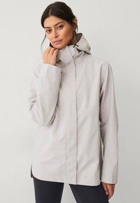 Helle, graue, wasserdichte Jacke mit hohem Kragen, verstellbare Kapuze und Taschen. Glatte Textur mit matter Oberfläche und minimalistischem Design.