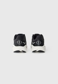 Schwarze Laufschuhe mit einem Obermaterial aus Mesh, auffälligen weißen Akzenten, einer gepolsterten Sohle und einem Logodruck an der Ferse.