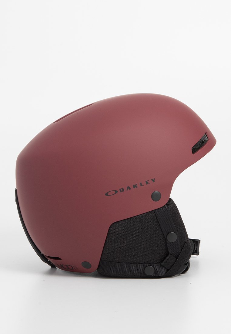 Roter mattschwarzer Skihelm mit glatter Außenseite, schwarzem Netzfutter, verstellbaren Riemen und Belüftungsöffnungen. Mit Oakley-Branding.
