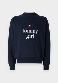 Marineblå sweatshirt med rund halsudskæring, lange ærmer og ribbede manchetter. Har broderet "tommy girl"-tekst og et stjernelogo.