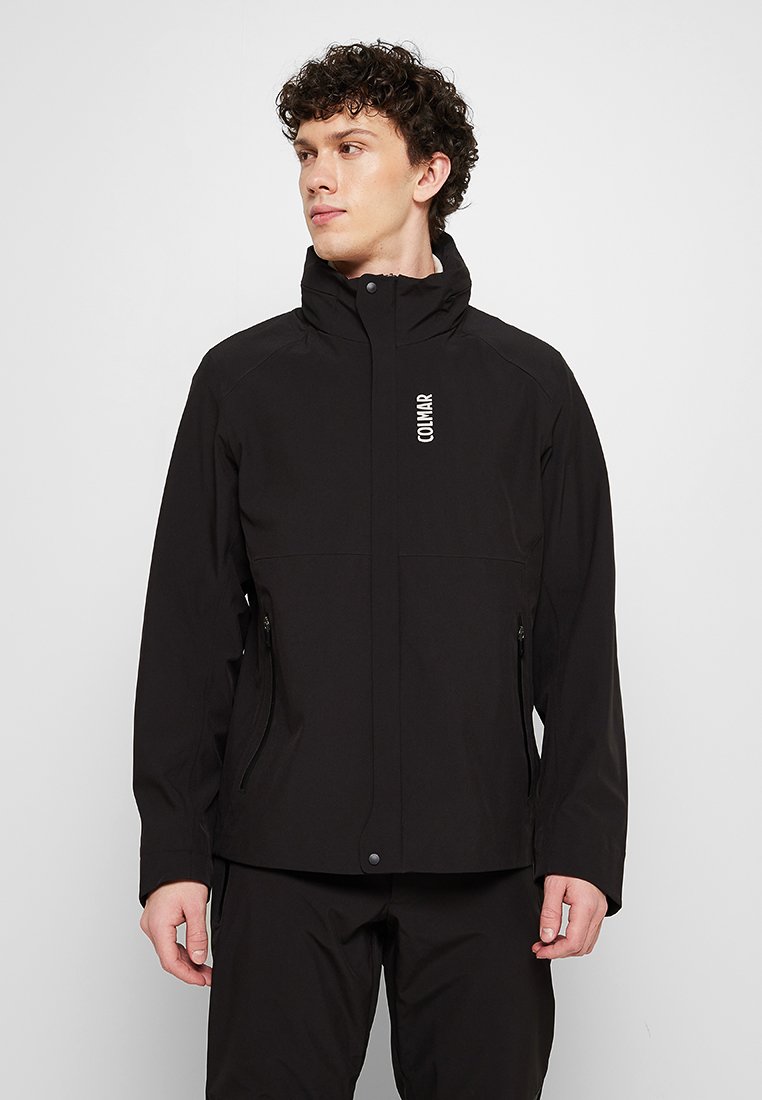 Giacca nera impermeabile con colletto alto, tasche con zip e dettagli di logo minimalisti. Texture liscia e vestibilità su misura.