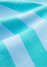 Tissu rayé bleu et turquoise avec un motif texturé tissé et des plis doux créant des ombres légères.