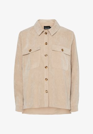 Bež košulja jakna od manšetra s ovratnikom, dva džepa na prsima i velikim okruglim gumbima. Mekana tekstura s vertikalnim rebrastim detaljima.