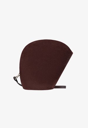 Brūns zamšādas maisiņš ar izteiksmīgu asimetrisku formu, ar melnu siksniņu un sudraba detaļām. Gluda tekstūra, minimālisma dizains.