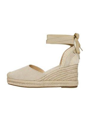 Espadrille compensée beige à bout fermé, talon tissé, semelle en jute tressée et bride à nouer autour de la cheville.