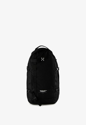 Grand sac à dos noir avec le logo "TIGHT", plusieurs sangles, boucles latérales et une poignée supérieure, présenté sur un fond blanc.