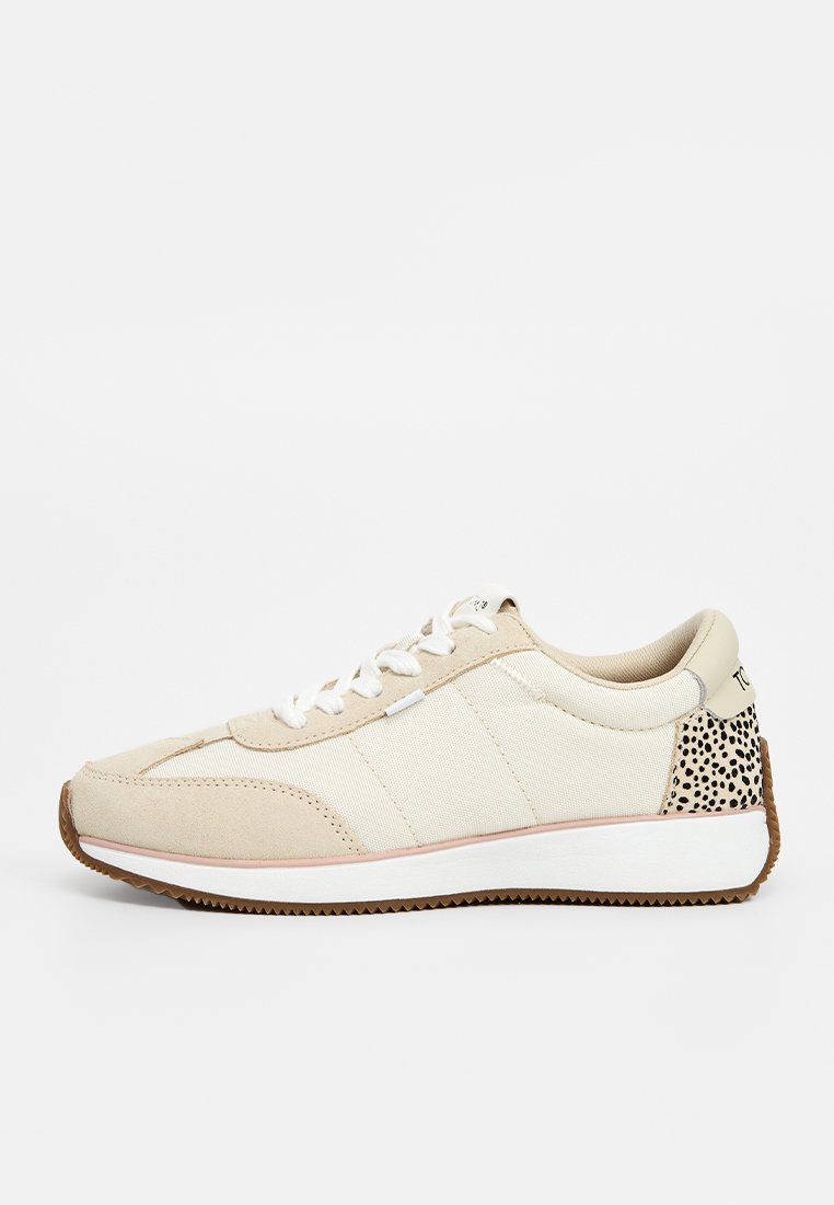 Zapatillas bajas beige con cordones blancos, entresuela blanca, suela de goma y patrón negro moteado en el talón.