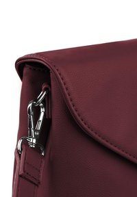 Bordová kožená kabelka s hladkým povrchem, se stříbrným kovovým uzávěrem a prošitou klopou na zavírání.