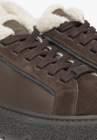Hnědé tenisky s kombinací semiše a nylonu, šněrovací design, měkká fleecová podšívka a texturovaná gumová podrážka s chunky vzhledem.