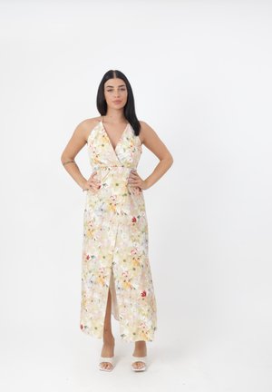 Robe maxi fleuri aux couleurs pastel avec un décolleté halter, une fente à l'avant et une taille cintrée. Tissu léger avec une texture douce.