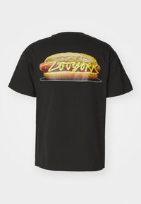 Sort bomulds t-shirt med et farverigt hot dog-grafik og "ZOYORK" tekst trykt på ryggen, med korte ærmer og design med rund hals.
