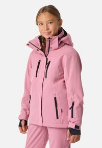 Veste imperméable rose avec capuche, dotée de accents de fermeture éclair noirs, de multiples poches et de poignets à velcro ; texture lisse, design élégant.