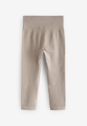 Leggings côtelés beiges avec une large ceinture élastique et des jambes ajustées. La texture est douce et agréable, idéale pour un port confortable.