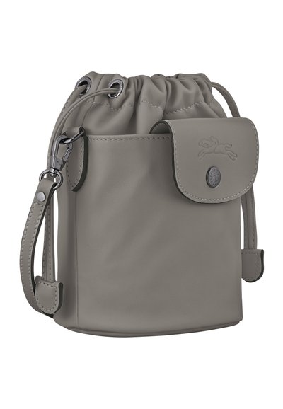 Gray leather drawstring bag with a rounded base, smooth texture, adjustable strap, and subtle logo detail on a front flap.