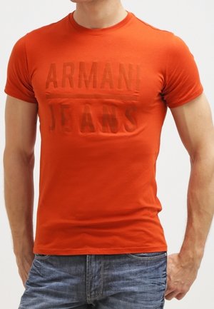 T-shirt orange à manches courtes en coton avec un col rond et un logo "ARMANI JEANS" subtilement embossé sur le devant.
