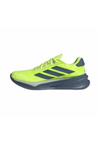 Chaussure de sport vert citron avec des accents bleu marine, tige texturée et logo à trois bandes. Présente une semelle épaisse grise pour un amorti supplémentaire.