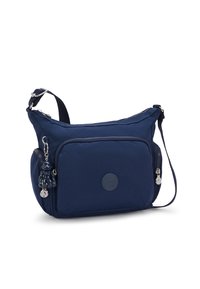 Borsa a spalla blu navy realizzata in tessuto, con una tasca frontale con zip, un logo circolare e un accessorio portachiavi. Inclusa tracolla regolabile.