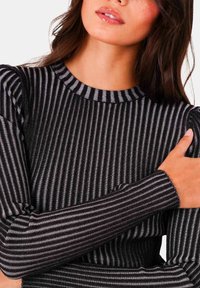 Zwart en grijs gestreepte long-sleeve top met een geribbelde textuur en een ronde hals. Accent van zachte stof en aansluitende mouwen zijn zichtbaar.