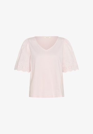 Vaaleanpunainen T-paita, joka on valmistettu puuvillasta. Siinä on V-pääntie, lyhyet puffhihat, joissa on brodeerattuja kukkakuoseja, ja suora helma.