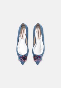 Para spiczastych balerinek z denimu, ozdobionych kolorowymi koralikami i cekinami na przodach, z srebrną podszewką i etykietą "custommade" wewnątrz.