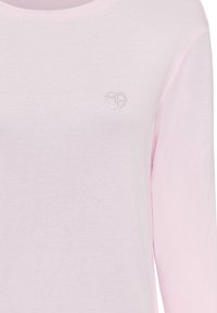 Helles rosa Langarmoberteil aus weichem Stoff, das ein kleines Herzdesign mit den Initialen "MB" aus Strass auf der Brust zeigt.