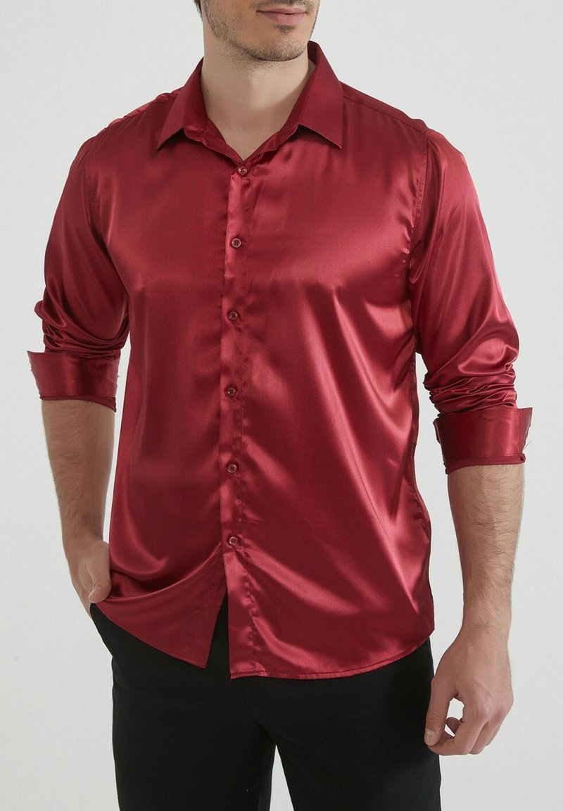 Chemise rouge en satin à manches longues avec col pointu, fermeture à boutons sur le devant et poignets retroussés. Texture lisse et brillante avec une coupe ajustée.