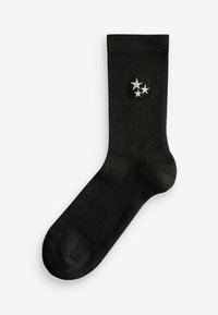Schwarze Socke aus einem glatten Material mit drei dekorativen Sternen in Silber und Gold nahe der Oberkante. Standard Knöchellänge.