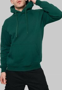 Hoodie vert en mélange de coton, avec une poche kangourou, une capuche avec cordon, des poignets côtelés et une coupe décontractée.