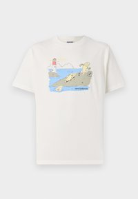 T-shirt de algodão branca com uma estampa divertida de peixes e um farol, com o texto "new balance" em azul abaixo da ilustração.