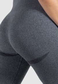 Gray ribbed leggings with a close-fitting design, featuring textured fabric and a black accent detail near the thigh.
