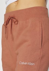 Rustinvärdiga träningsbyxor i en bomullsblandning, med dragsko i midjan, sidofickor och broderad "Calvin Klein"-logotyp i vitt.