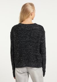Flauschiger schwarzer und grauer Strickpullover mit entspannter Passform, geripptem Halsausschnitt und Bündchen; strukturiertes Design mit leicht verkürzter Länge.