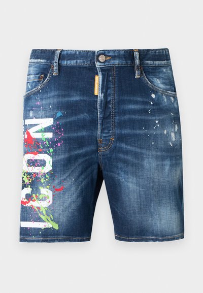 Shorts en denim à lavage foncé avec une texture usée, présentant des éclaboussures de peinture multicolores et un lettrage graphique blanc audacieux à l'avant.
