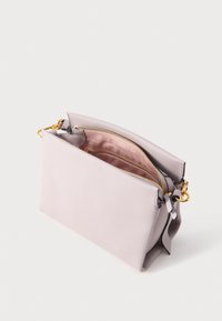 Vaaleanpunainen nahkainen käsilaukku, jossa on kultainen vetoketju, avattuna paljastaen vaaleanpunainen sisävuori ja kultainen lukko sivuhihnassa.