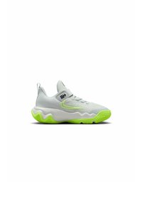 Zapatilla deportiva de color gris claro con parte superior texturizada, acentos en verde neón y un diseño de suela ondulada. Presenta una correa elástica para un ajuste seguro.