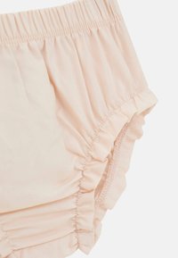 Pantaloni bloomers leggeri di colore rosa chiaro, realizzati in un morbido tessuto con cintura elastica e bordi arricciati. Il materiale appare liscio con delicati dettagli di arricciatura.
