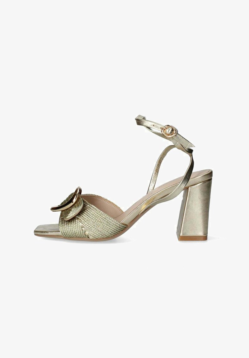 Kultaiset korkokengät, joissa on kudottu pinta, avonainen kärki, suuri koristeellinen silmukka ja nilkkahihna soljella.