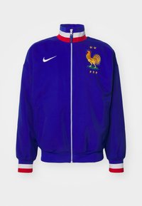 Nike blå jakke med høj krave, hvid lynlås, elastiske manchetter med røde og hvide striber, med et broderet kyllingemblem og "FFF."