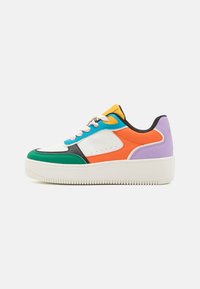 Colorful sneaker featuring a white leather base, green, orange, purple accents, and textured rubber sole with a raised platform and striped laces.
