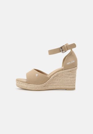 Sandales compensées beiges avec une semelle intermédiaire en jute tressé, une tige en tissu, une lanière à la cheville et un détail de logo à l'arrière. Design ouvert sur les orteils.