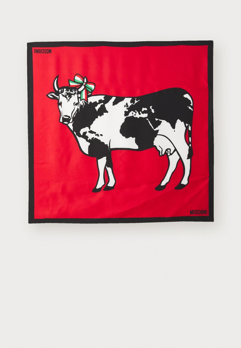 Zīda šalle ar melnbaltu govs dizainu uz spilgti sarkana fona, ar dekoratīvu zaļu un baltu loku. Melnā mala ar "Moschino".