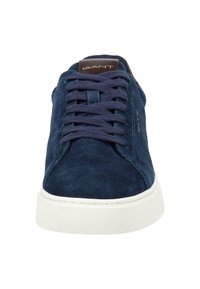 Zapatillas de ante azul marino con suela de goma blanca, punta redonda y cierre de cordones. Presentan lengua con logotipo y detalle de costura en contraste.