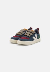 Bunte Sneakers aus einer Mischung aus marineblauem, burgunderfarbenem und grünem Wildleder. Mit drei Klettverschlüssen, einem weißen Logo und einer strukturierten Gummisohle.
