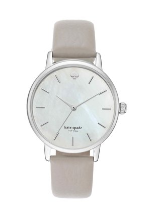 Okrągły srebrny zegarek z jasnobeżowym skórzanym paskiem, minimalistyczną białą tarczą, srebrnymi indeksami godzin i napisem "kate spade new york".