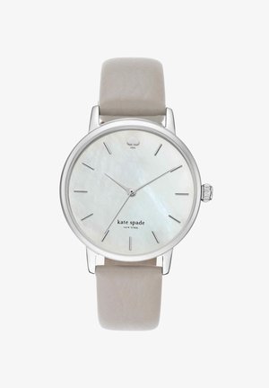 Orologio rotondo in argento con cinturino in pelle beige chiaro, quadrante bianco minimalista, indici delle ore in argento e testo "kate spade new york".