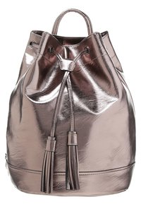 Metalen rosegouden rugzak met een trekkoordsluiting, twee decoratieve franje, en een gladde, glanzende textuur. Ronde vorm met korte handvatten.