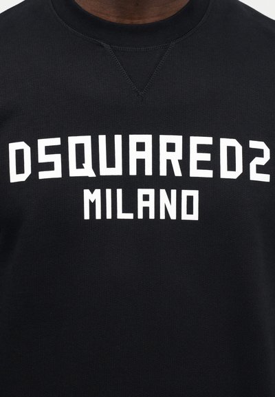 Schwarzer Sweatshirt mit strukturierter Oberfläche, versehen mit fettem weißen Schriftzug "DSQUARED2 MILANO" quer über der Brust. Klassischer Rundhalsausschnitt und schmale Passform.