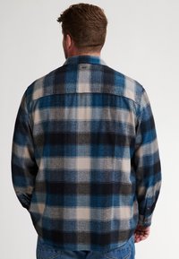 Heren geruite flanellen overhemden in blauw, zwart en grijstinten. Beschikt over een button-down kraag en lange mouwen, met een gestructureerde stof.